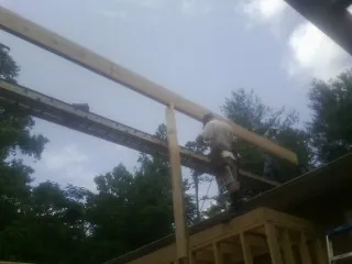 Carpenter setting a ridge beam over a new addition frame — Ice Dam Removal by Roofing Brothers in Taylorsville