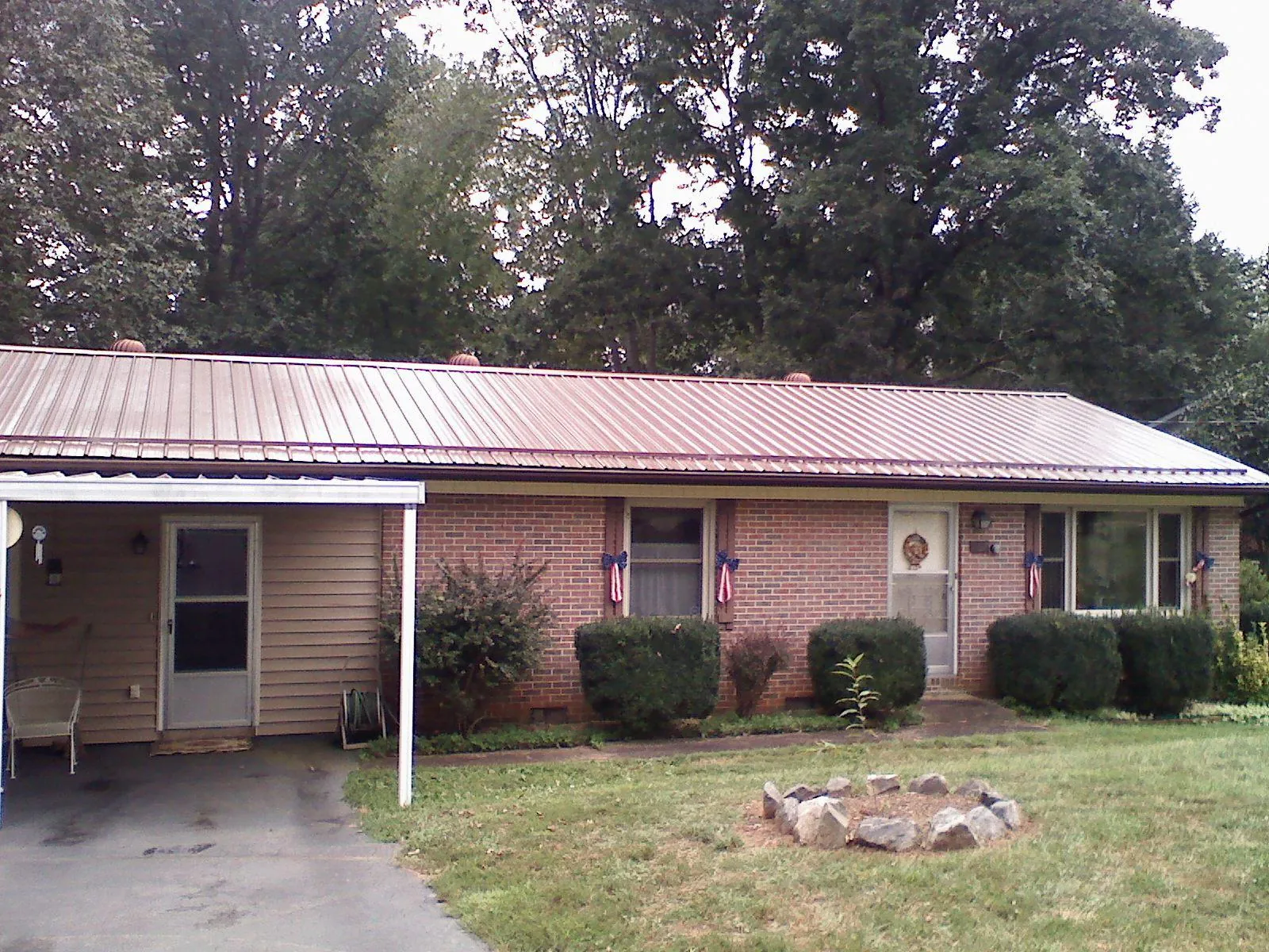 Bronze metal roof and carport on a brick ranch home — Roof Repair work by our crew in Taylorsville